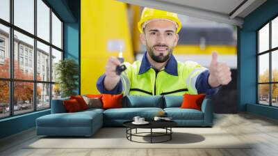 construction worker holding keys with thumbs up Wall mural