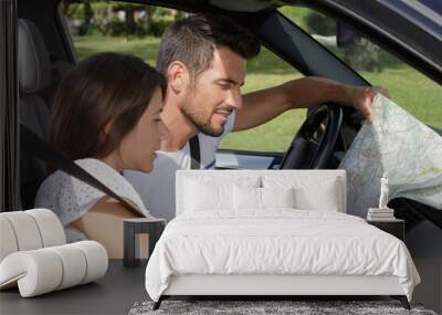 couple looking at a map in the car Wall mural