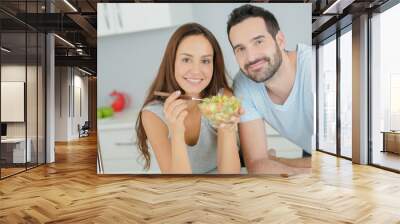 Couple sharing a salad in the kitchen Wall mural