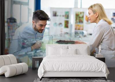 customer choosing delicious chocolate in shelf Wall mural