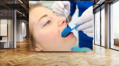 Dentist using a mouth guard on a a woman Wall mural