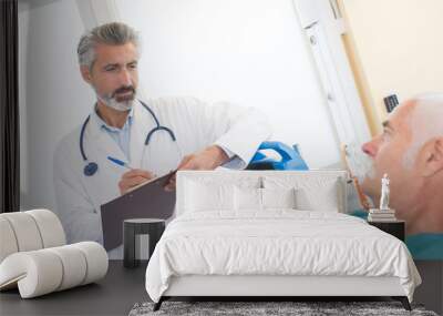 doctor making anamnesis with senior patient lying Wall mural