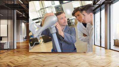 Engineer with model of aircraft tail and two students Wall mural