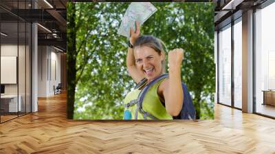 excited female hikers holding a map Wall mural