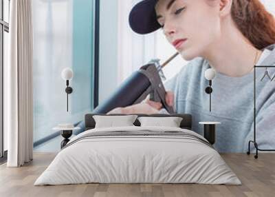 female construction worker installing window in house Wall mural