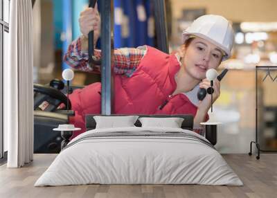 female fork lift truck driver working in factory Wall mural