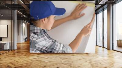 female painting a wall with masking tape and brush Wall mural