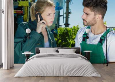 female vineyard worker on the phone with co-worker Wall mural