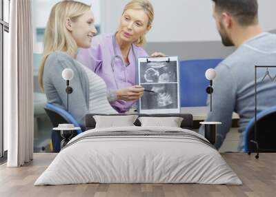 gynecologist showing ultrasound photo to a couple Wall mural