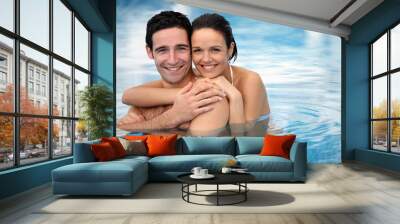 Happy couple hugging in a swimming-pool Wall mural