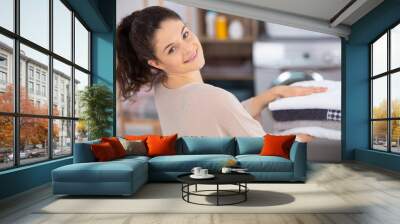 happy young woman holding folded towels Wall mural