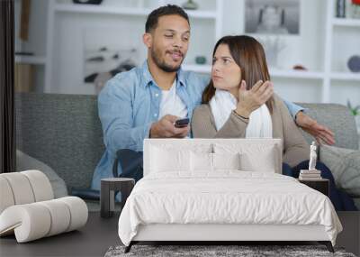 injured boyfriend watching tv with girlfriend Wall mural