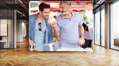 male couple in market choosing melons Wall mural