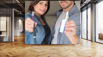 man and woman holding two versions of an electronic cigarette Wall mural