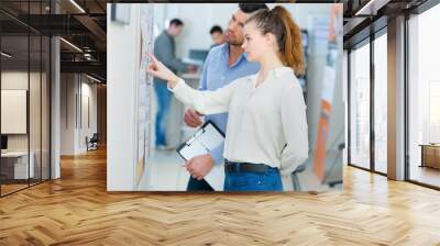 man and young lady consulting notice board Wall mural