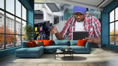 man leaning over open photocopier during maintenance repairs Wall mural