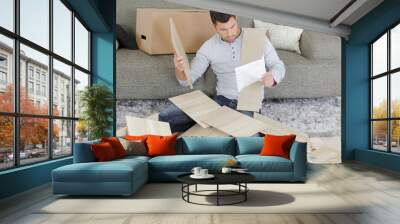 Man surrounded by pieces of flat pack furniture Wall mural