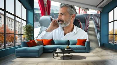 mature man talking on cellphone on empty bus Wall mural