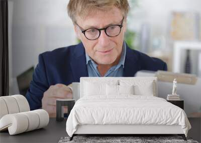 mature man using laptop on desk at home Wall mural