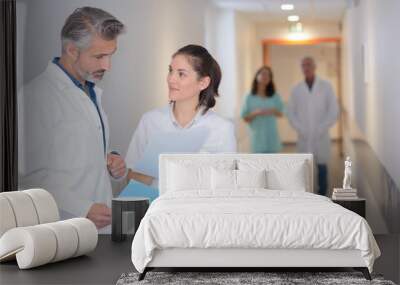 Medics conferring in hospital corridor Wall mural