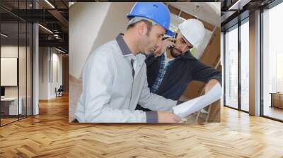 men on indoor worksite looking at plans Wall mural