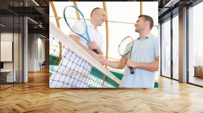 Men shaking hands over the tennis court net Wall mural