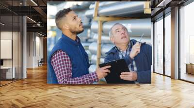 men with clipboard looking up in building materials yard Wall mural