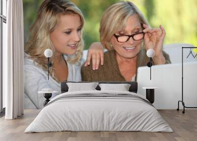 Mother and daughter sat with laptop Wall mural