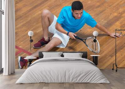 player with squash ball and racket relaxing after training Wall mural