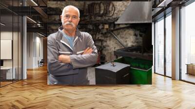 portrait of confident blacksmith standing by forge in workshop Wall mural