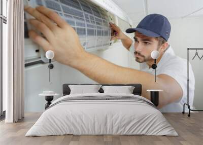 portrait of mid-adult male technician repairing air conditioner Wall mural