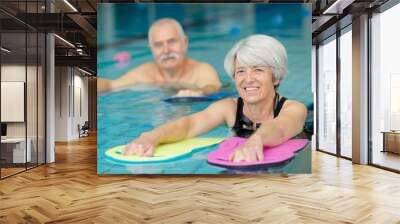 portrait of senior man and woman in swimming pool Wall mural