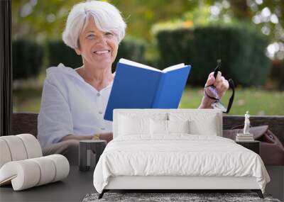 retired woman reading a book on the bench Wall mural