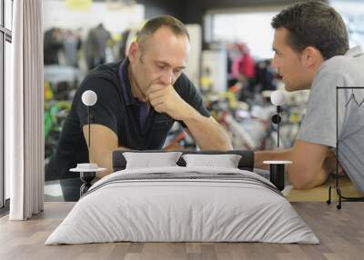 salesman asking a man to sign receipt in store Wall mural