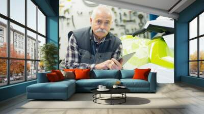 senior salesman posing next to jet ski in his store Wall mural