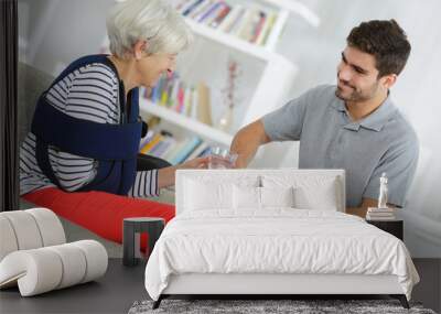 smiling senior woman with young male nurse Wall mural