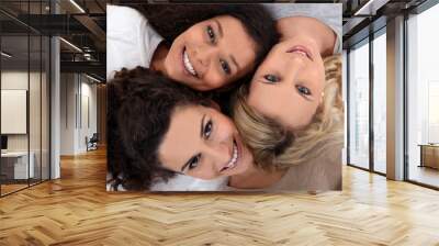 three female friends laying down together Wall mural