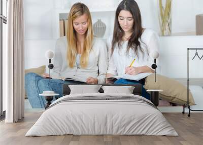 two concentrated students on a couch in the living room Wall mural