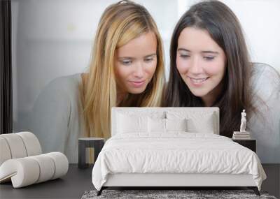 two female friends reading a text message Wall mural