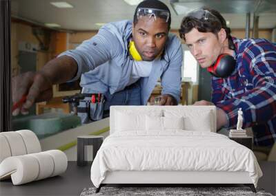 two male carpenters working together in workshop Wall mural