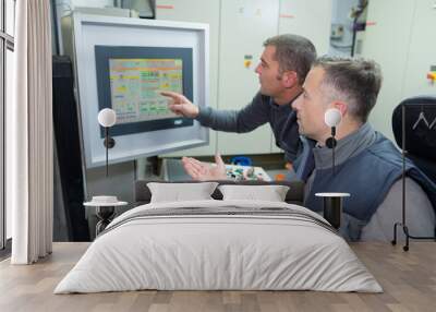 two men talking and sitting in the control room Wall mural