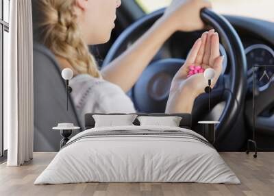 woman holds tablets at the steering wheel while driving Wall mural