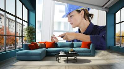 woman installing window handle with screwdriver indoors Wall mural