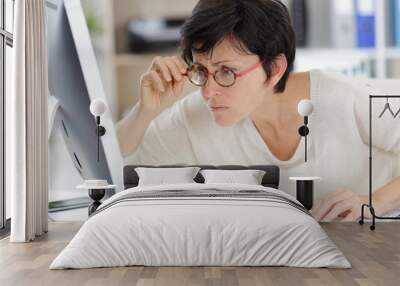 woman looking closely at computer screen Wall mural