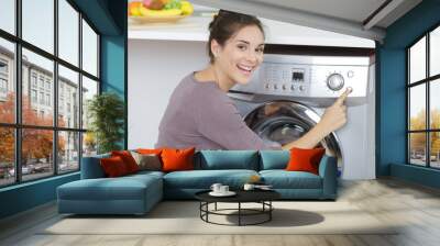 woman pressing button to start washing machine Wall mural