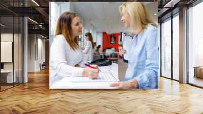 woman talking to colleague in office Wall mural