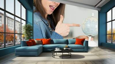 woman winkand and pointing to a globe Wall mural