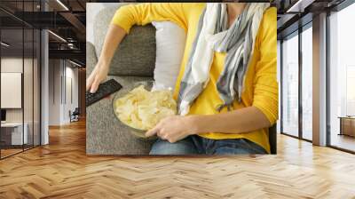 woman with bowl of chips and tv remote control Wall mural