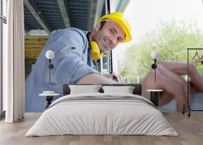 worker is working on renovation of apartment measuring window Wall mural