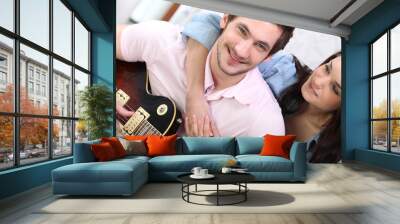 young couple playing a guitar at home Wall mural